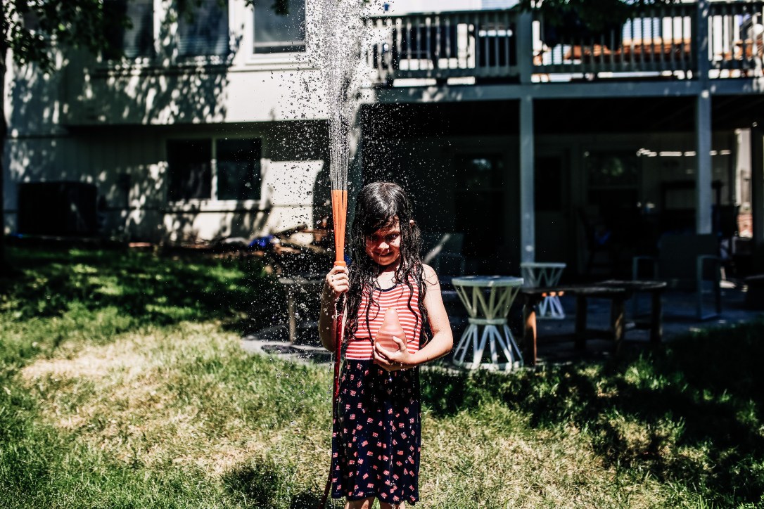 girl hose splash backyard documentary photography summertime