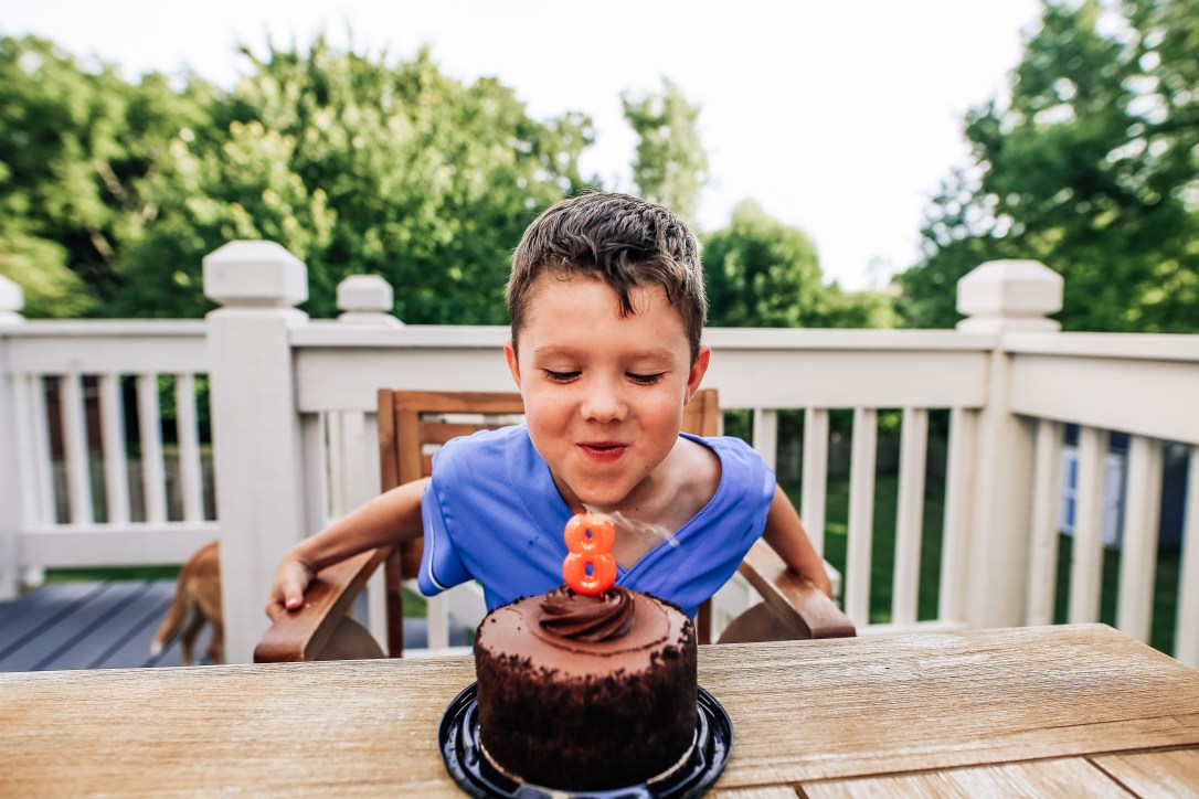 birthday boy blowing out candles on cake