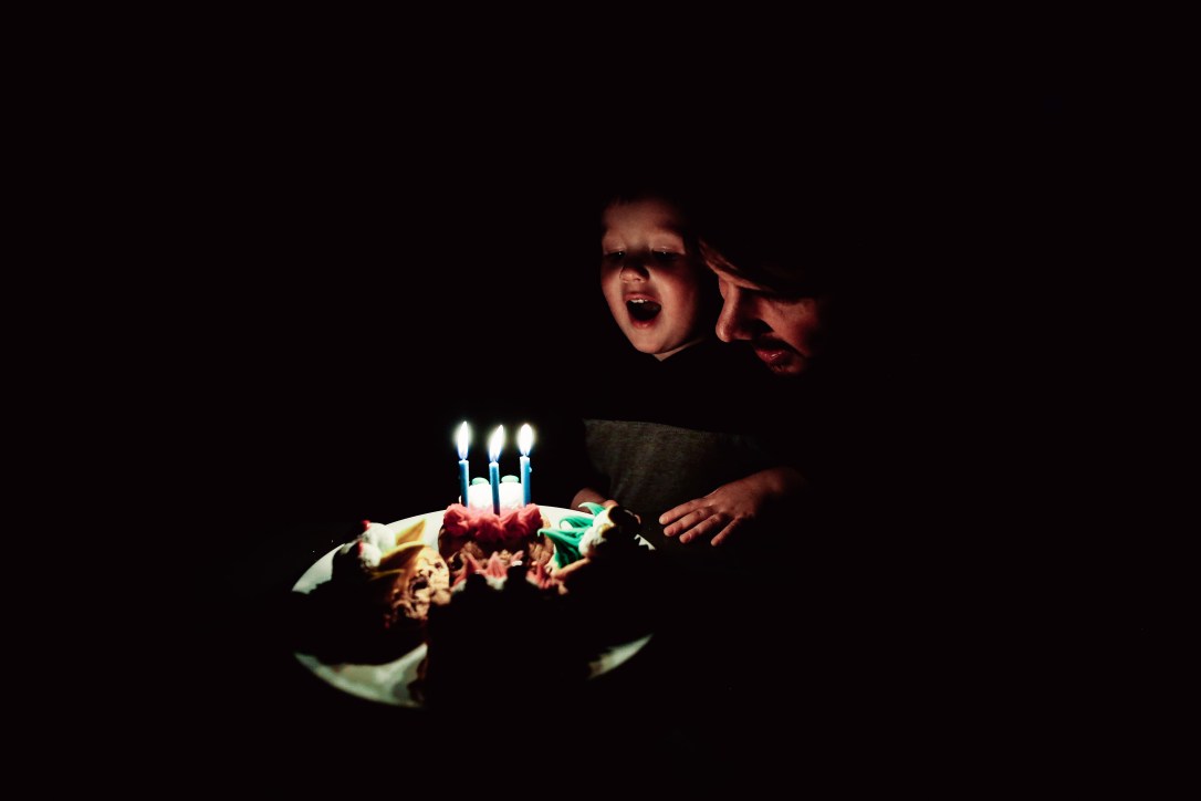 birthday boy blowing out candles on cake