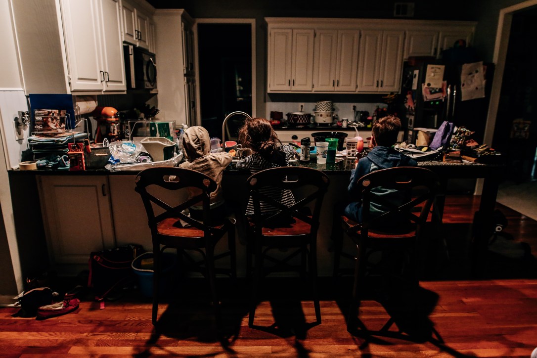 Three kids kitchen messy indoor light documentary photography